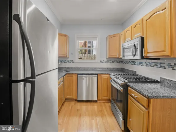 a kitchen with stainless steel appliances granite countertop a refrigerator a stove and a sink