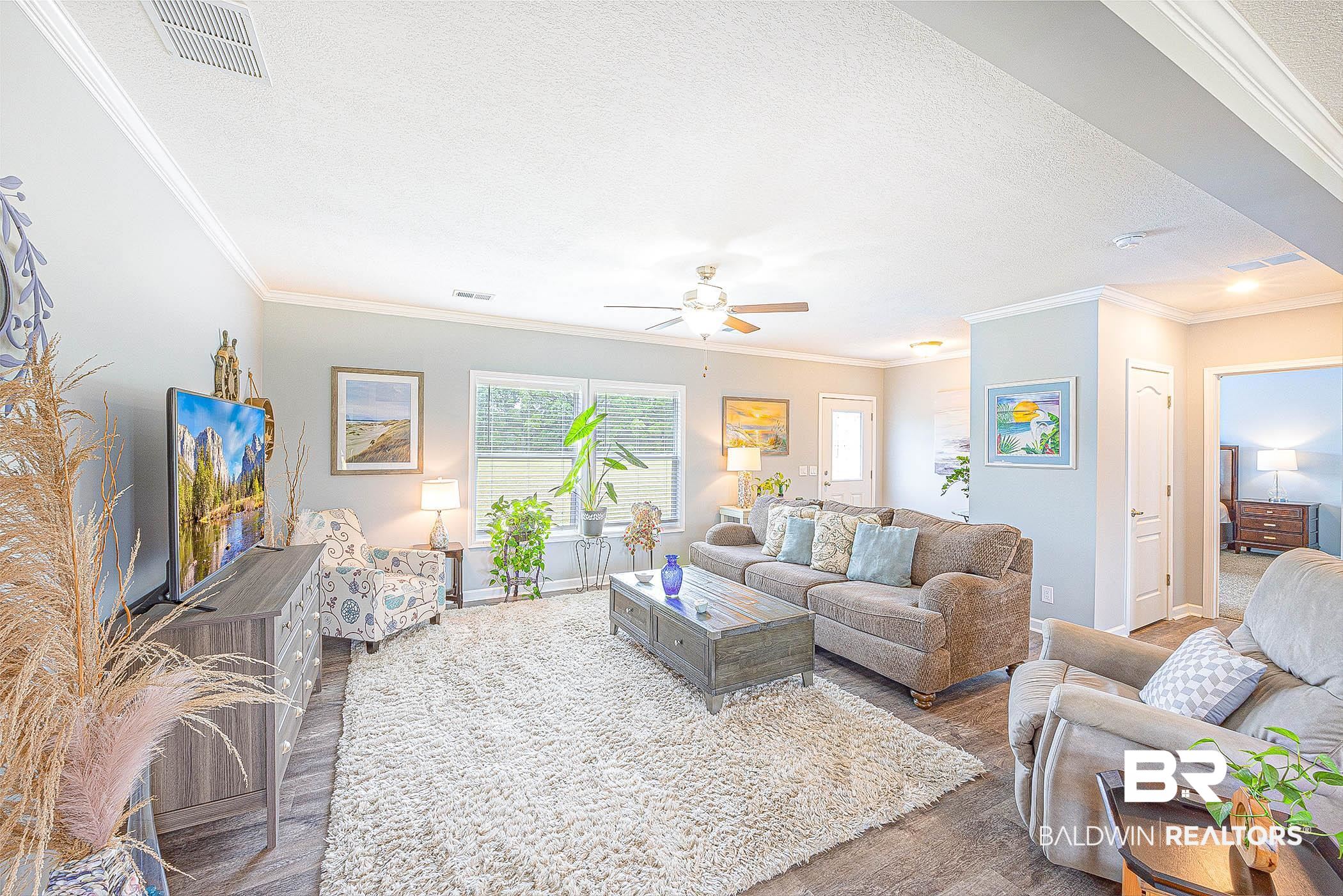 16000 John Bauer Road Summerdale, AL 36580 - Photo 10 of 34 Living area featuring ornamental molding, visible vents, a textured ceiling, and wood finished floors