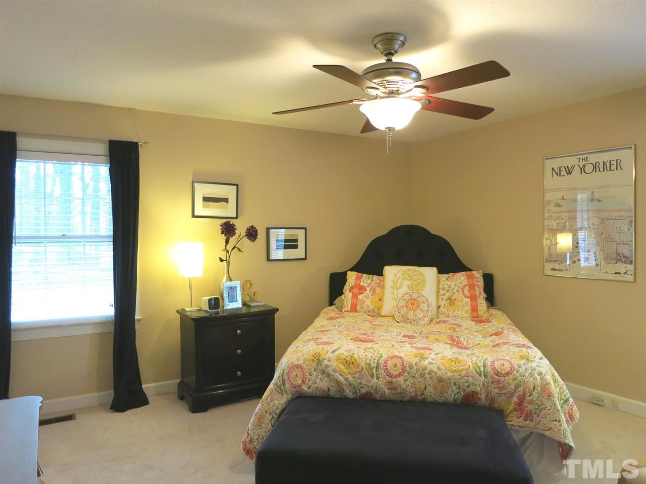 6408 Wynbrook Way Raleigh, NC 27612 - Photo 13 of 25 a bedroom with a bed and a chandelier