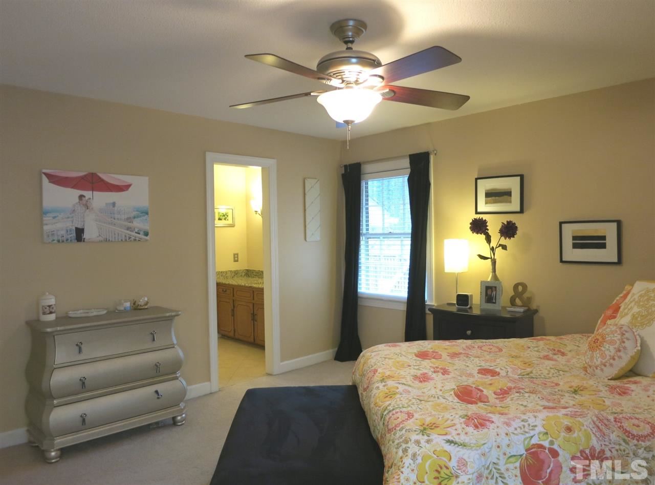 6408 Wynbrook Way Raleigh, NC 27612 - Photo 14 of 25 a bedroom with a bed and a chandelier