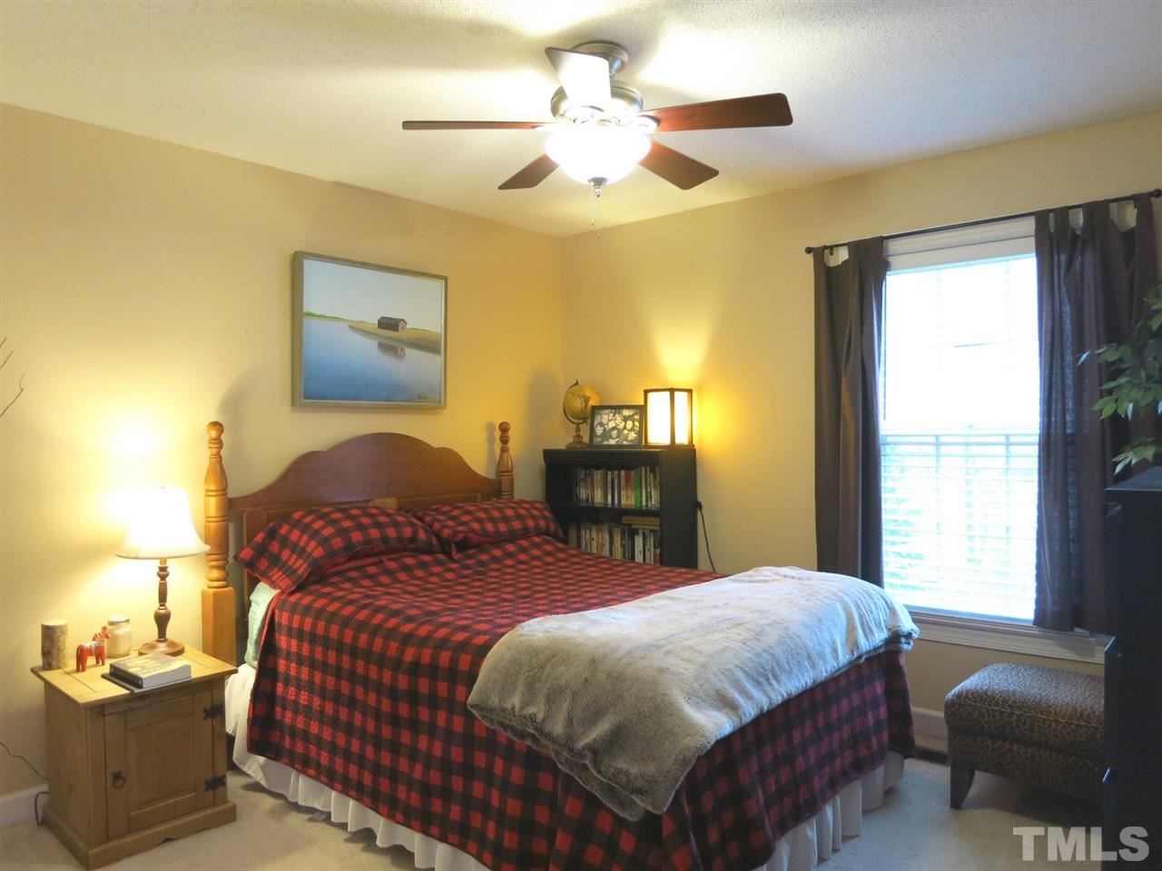 6408 Wynbrook Way Raleigh, NC 27612 - Photo 17 of 25 a bedroom with a bed and a chandelier