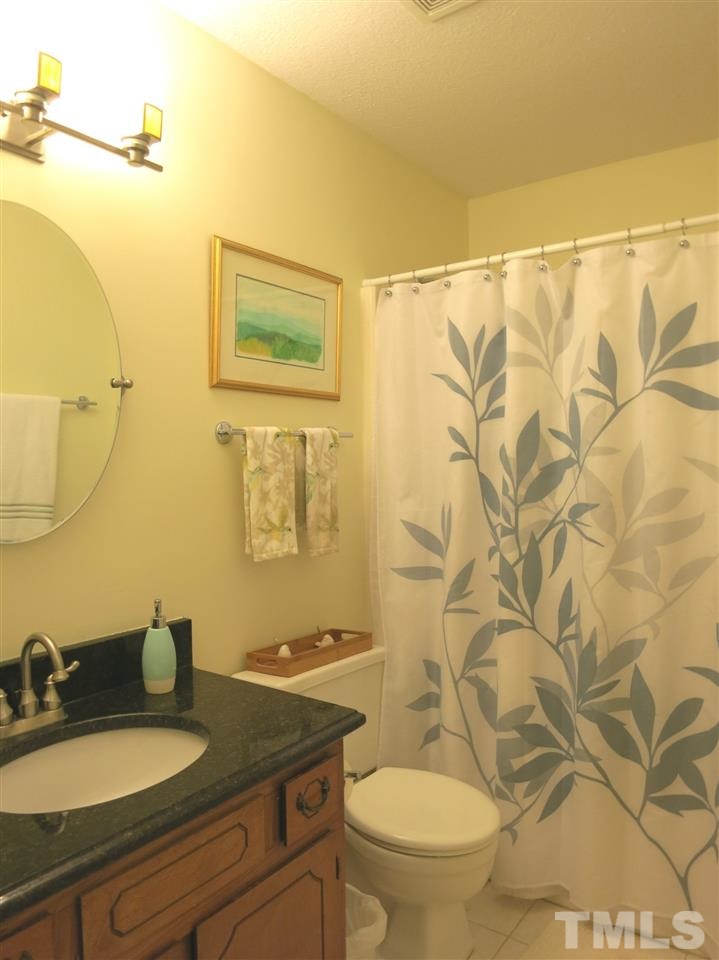 6408 Wynbrook Way Raleigh, NC 27612 - Photo 19 of 25 a bathroom with a granite countertop sink and a mirror