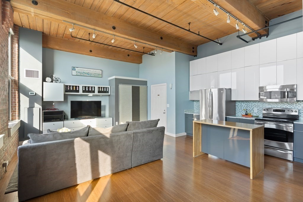 320 West 2nd Street, Unit 413 Boston, MA 02127 - Photo 3 of 20 a living room with stainless steel appliances kitchen island granite countertop a refrigerator a stove top oven a sink dishwasher and white cabinets with wooden floor