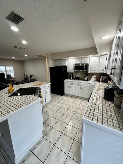 40 High Point Road, Unit D202 Tavernier, FL 33070 - Photo 5 of 28 a kitchen with stainless steel appliances a stove a sink a microwave and a refrigerator