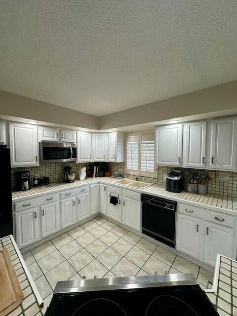 40 High Point Road, Unit D202 Tavernier, FL 33070 - Photo 6 of 28 a kitchen with granite countertop a sink stainless steel appliances and white cabinets