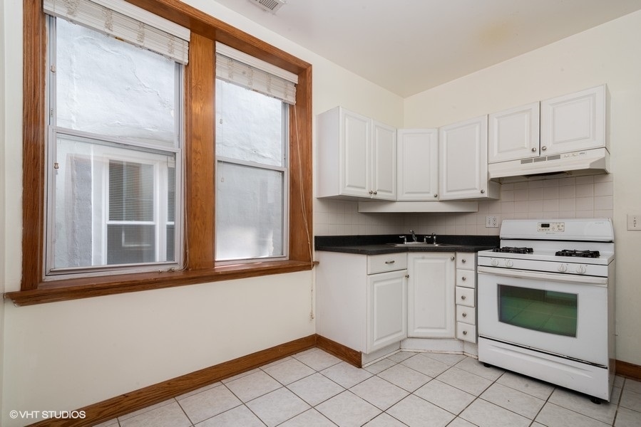 819 South Carpenter Street, Unit 2R Chicago, IL 60607 - Photo 2 of 6 a kitchen with white cabinets and a stove top oven