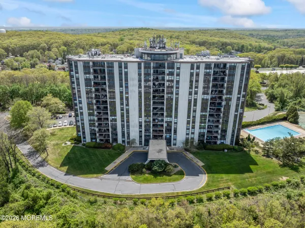 a view of a multi story residential apartment building with a yard