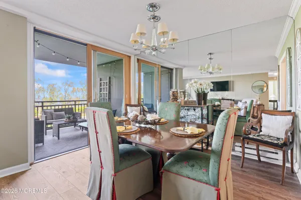 a dining room with furniture a chandelier and wooden floor