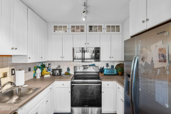 a kitchen with cabinets stainless steel appliances and a sink