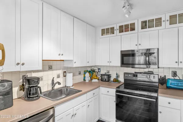 a kitchen with stainless steel appliances a refrigerator sink and cabinets