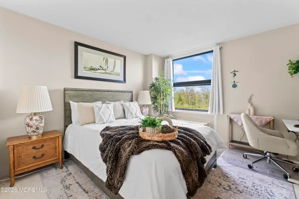 a bedroom with a bed a table and a chair with window