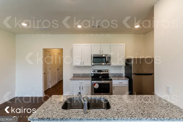 a kitchen with stainless steel appliances granite countertop a refrigerator sink and stove
