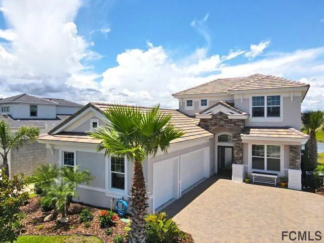 a front view of a house with a yard and potted plants