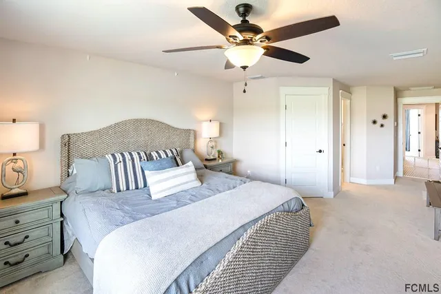 a bedroom with a large bed and a chandelier