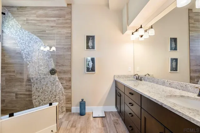 a spacious bathroom with a granite countertop sink a toilet a mirror and shower