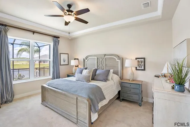 a bedroom with a large bed and a chandelier fan