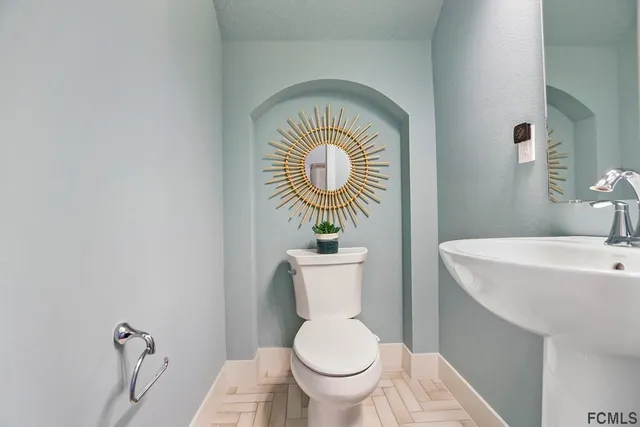 a bathroom with a toilet a sink and mirror