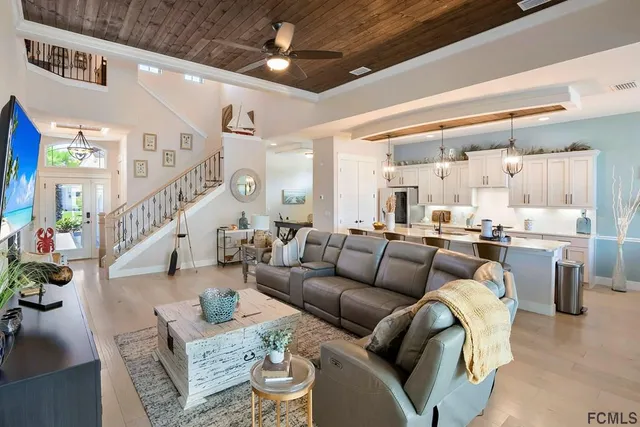 a living room with furniture and a view of kitchen