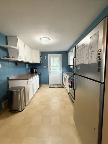 a kitchen with stainless steel appliances a refrigerator sink and cabinets