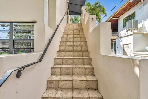 a living room with furniture and a refrigerator