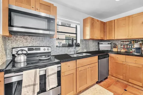 a kitchen with stainless steel appliances granite countertop a sink stove and cabinets
