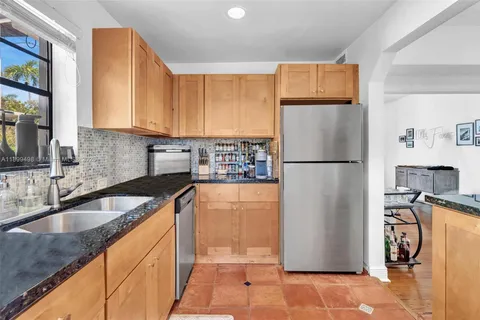 a kitchen with granite countertop a refrigerator and a sink