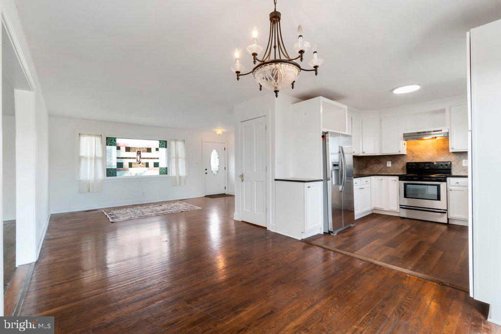 711 Ridge Road Mount Airy, MD 21771 - Photo 11 of 47 a view of a kitchen with a refrigerator wooden floor and a ceiling fan