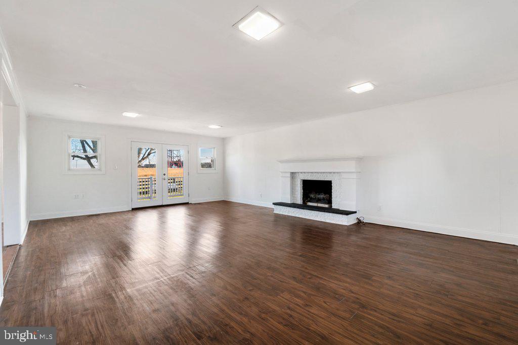 711 Ridge Road Mount Airy, MD 21771 - Photo 17 of 47 an empty room with wooden floor and fireplace