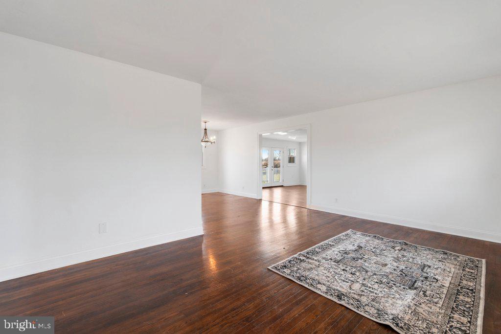 711 Ridge Road Mount Airy, MD 21771 - Photo 9 of 47 an empty room with wooden floor and a rug
