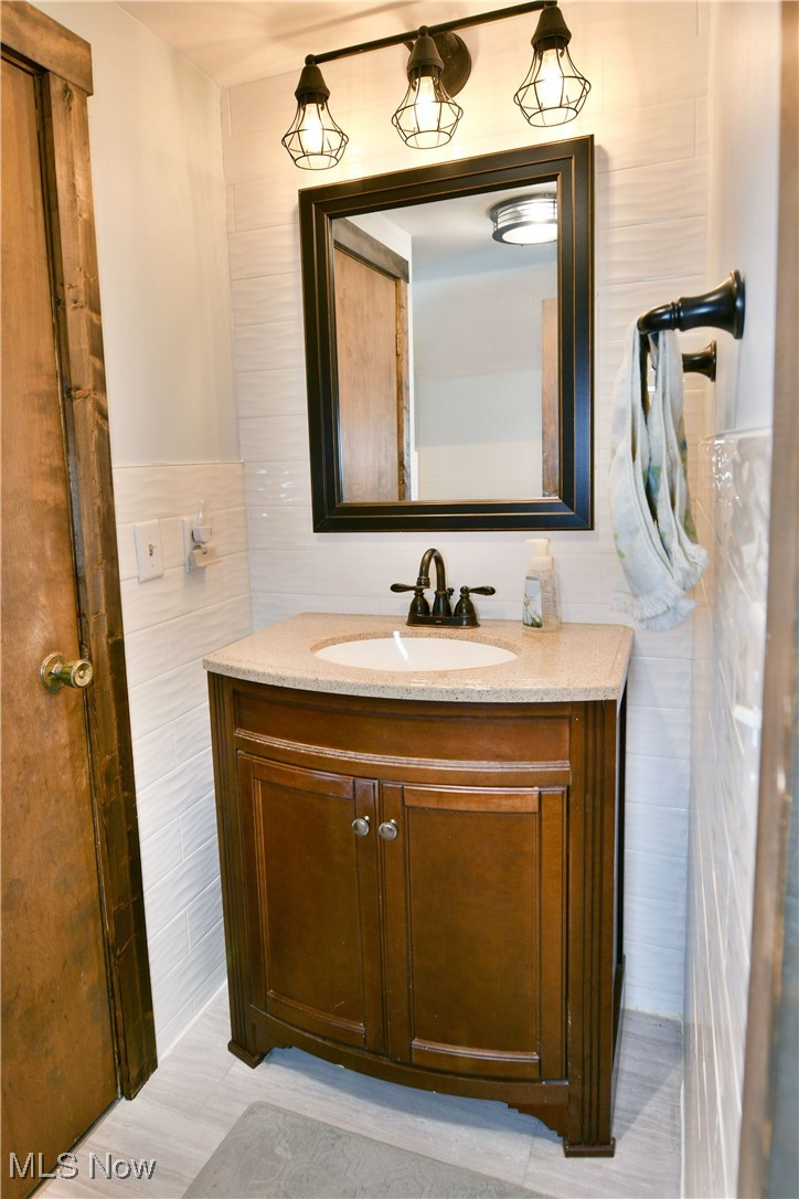 1509 State Road Northwest Warren, OH 44481 - Photo 45 of 49 Bathroom with vanity and tile walls