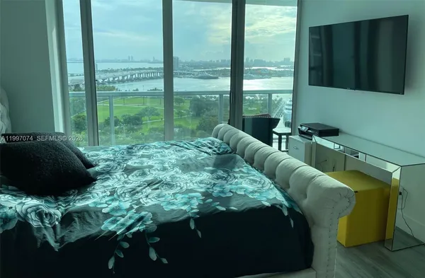 a bed sitting in a bedroom next to a window