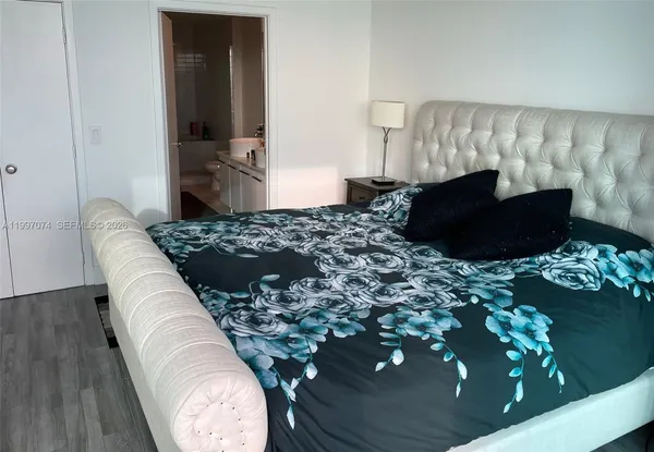 a bed sitting in a bedroom next to a window with potted plants