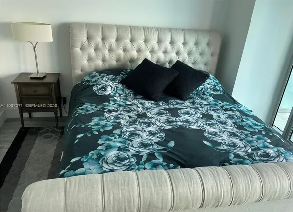 a bed sitting in a bedroom next to a large window