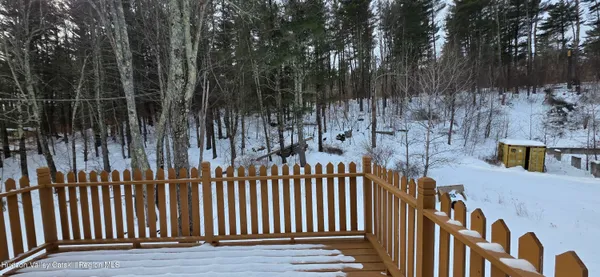 a view of balcony with wooden floor and fence and a potted plant