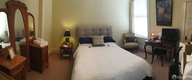 a bedroom with a bed and flat screen tv