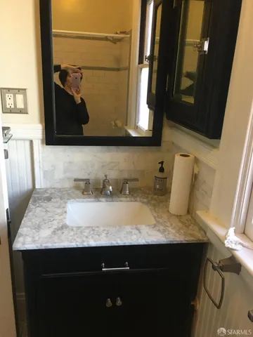 a bathroom with a granite countertop sink and a mirror