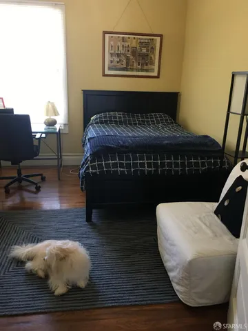 a view of a bedroom with furniture and wooden floor