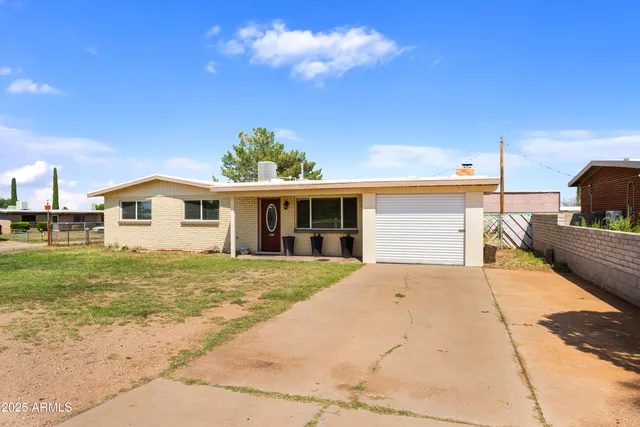 a view of a yard in front of a house with a large tree