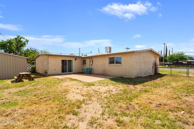 a view of a house with backyard and a tree