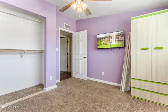 an empty room with a window and a fan