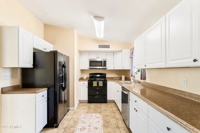 a kitchen with stainless steel appliances a refrigerator sink and cabinets