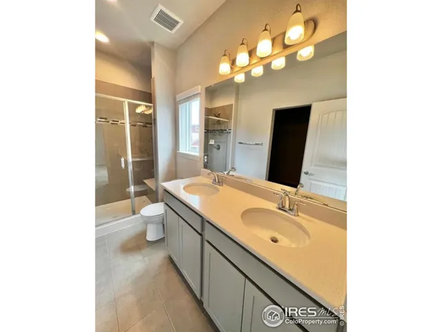a bathroom with a granite countertop sink a large mirror and a toilet