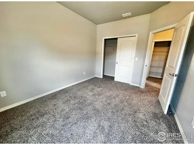 an empty room with a bench and mirror