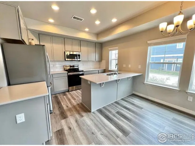 a kitchen with stainless steel appliances granite countertop a refrigerator sink and stove