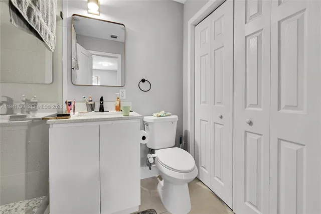 a bathroom with a toilet sink vanity and mirror