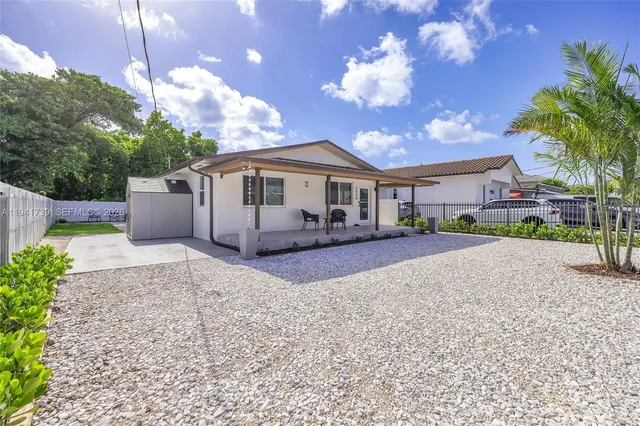 a front view of a house with a garden and trees