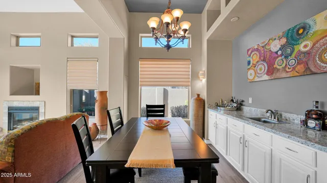 a view of a dining room with furniture a livingroom and chandelier