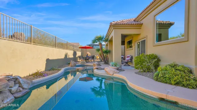 a view of a house with pool and chairs