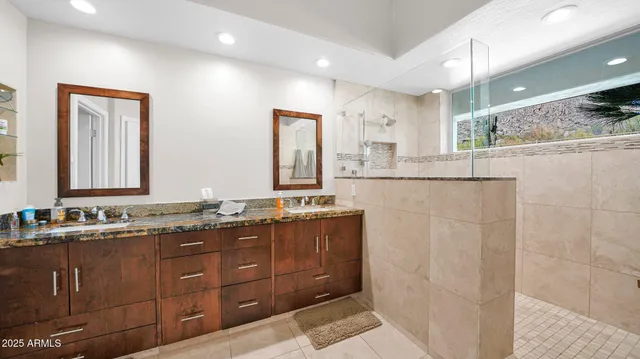 a bathroom with double vanity and a mirror