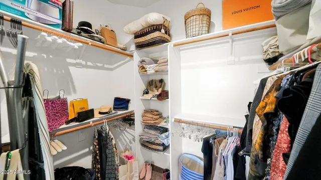 a view of walk in closet with clothes and shoes